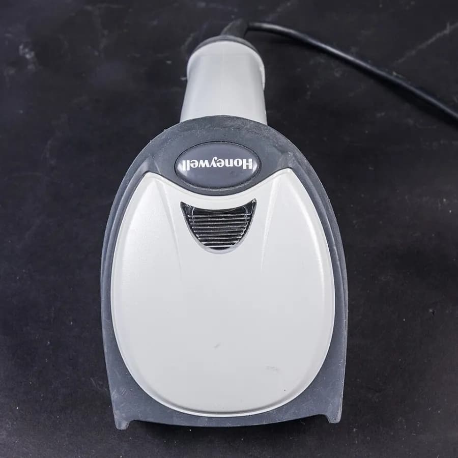 A handheld barcode scanner in its stand.