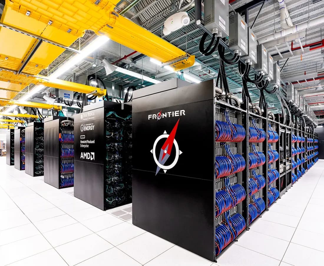 Rows of tall black cabinets of the Frontier supercomputer in a data centre, with overhead cable trays.