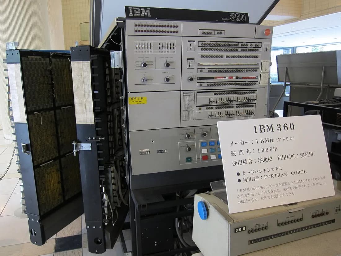 An IBM System/360 mainframe on display: tall grey cabinets with a control panel of switches and lights.